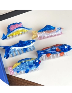 Detail view showing assorted ocean fish hair claws in marble acetate textures and colors