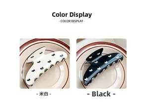 Detail view of large cream and black hair claws with dog pattern on ceramic plate