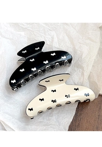 Detail view of black and cream acrylic hair claws featuring minimalist dog silhouette patterns