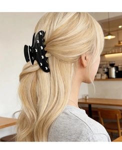 Rear view of a model wearing a large black cutout claw clip with white animal patterns