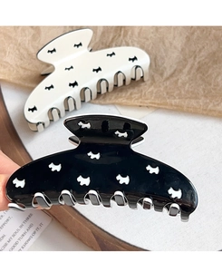 Detail of large claw clips featuring cute puppy pattern in black and white finish