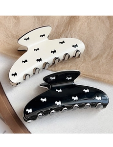 Detail of hollow dog pattern hair clips in black and white glossy acetate finish