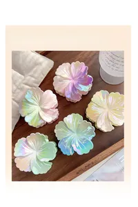 Détail de 5 pinces à cheveux plumeria dégradées avec fini nacré sur un bureau en bois