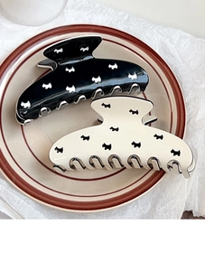 Detailed view of hollow dog pattern hair claws in black and cream resin finish