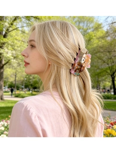 Dettaglio di una pinza per capelli color ambra con decoro animale su capelli biondi