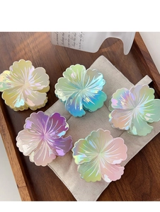 Gros plan détaillé de pinces à cheveux fleurs colorées avec un dégradé iridescent