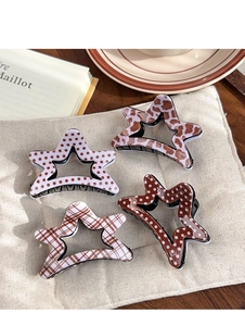 Detail of star-shaped acetate hair clips with leopard, plaid and polka dot patterns