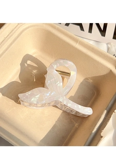 Detail of mermaid tail hair claw clip in pearlescent white with gold metal spring