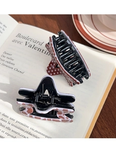 Detail of polka dot and patterned hair claw clips on a vintage book surface