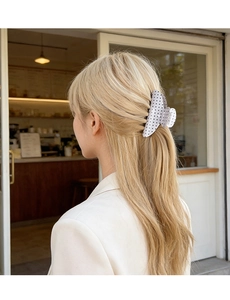 Chic polka dot hair claw clip securing a half-up hairstyle on light blonde hair