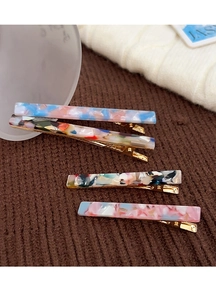 Close-up of tortoise shell pattern acetate hair clips on brown knitted texture fabric