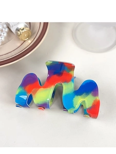 Dettaglio della grande molletta per capelli a onda in resina con effetto tie-dye colorato