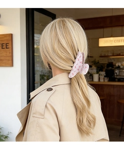Pince à cheveux florale avec fleurs de cerisier roses sur longs cheveux blonds de dos