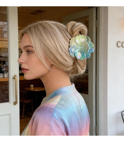Pince à cheveux fleur holographique dégradée sur un chignon pour un style vacances
