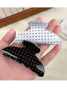 Close-up of black and white polka dot hair claws in a medium-sized glossy finish