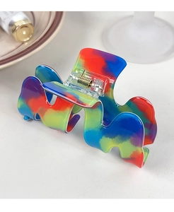 Dettaglio macro della pinza per capelli ondulata arcobaleno con molla in metallo oro