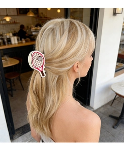 Detailed view of tennis racket hair claw clip styled on a blonde woman hair