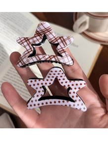 Detail of star-shaped hair clips in vintage plaid and polka dot acrylic patterns