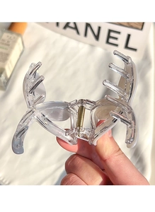 Close-up of a pearlescent mermaid tail hair claw clip held in hand with metal spring detail