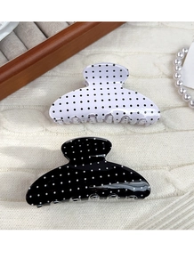 Detail of vintage black and white polka dot hair claws with glossy finish and dense teeth