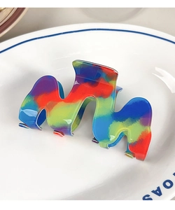 Dettaglio macro della molletta per capelli a onda arcobaleno con finitura lucida e colori vivaci