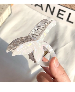Detailed macro of a pearlescent mermaid tail hair claw clip with golden metal spring