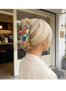 Modella che indossa una grande clip per capelli a onde colorata con motivi ad acquerello
