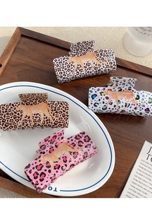 Detail of leopard print hair claws in four colors featuring golden cheetah motifs