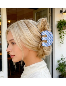 Blue and pink striped M-shaped hair claw clip styling a bun on a blonde model