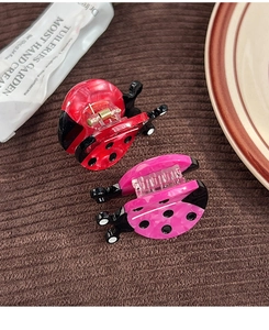 Close-up of red and pink ladybug hair clips made from premium acetic acid sheet