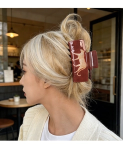 Deep red rectangular leopard print hair claw clip shown in a stylish half-body model shot