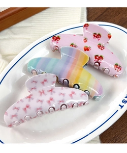 Gros plan de pinces à cheveux fleuries mignonnes avec motifs fraise et arc-en-ciel