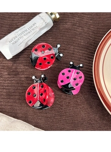 Detailed view of ladybug hair clips set in red and pink colors with acetate finish