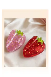 Detail of sweet strawberry hair claws in red and pink with translucent finish