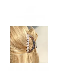 Détail d'une pince à cheveux motif écaille de tortue avec perles blanches élégantes