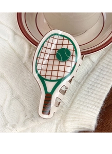 Detailed close-up of a tennis racket claw clip on a white knit background with coffee cup