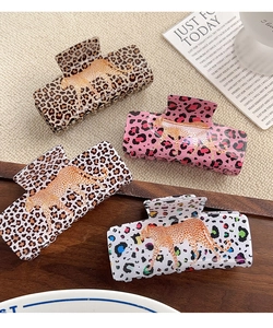 Close-up of four luxury leopard print PVC hair claws in various colors with leopard motifs