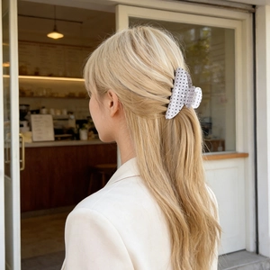 French retro white hair claw with black polka dots shown in a semi-tied hairstyle