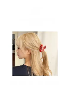 Gros plan d'une pince à cheveux à carreaux rouges avec texte RICH RICH sur modèle