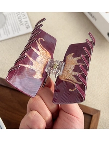 Detail of burgundy leopard hair claw clip showing a strong gold spring and patterns