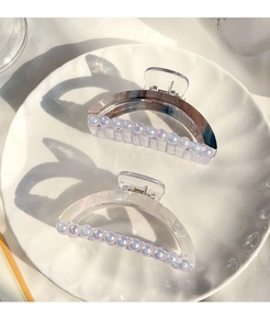 Détail de pinces à cheveux marbrées avec petites perles sur plateau céramique