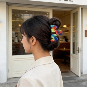 Molla per capelli colorata in PVC a forma di onda mostrata su un'acconciatura elegante