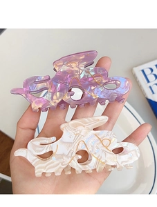 Détail de pinces à cheveux poulpe irisées en violet et blanc perlé avec des lignes dorées