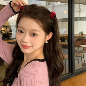 Sweet red ladybug hair clips with black dots worn by a smiling model in a cafe