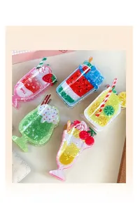 Dettaglio di 5 mollette per capelli a tema bevande estive con glitter e milkshake