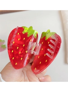 Detailed close-up of a sweet strawberry-shaped hair claw clip with glossy red finish