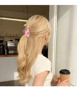 Pince à cheveux rose à pois avec lettrage KICH portée sur cheveux blonds