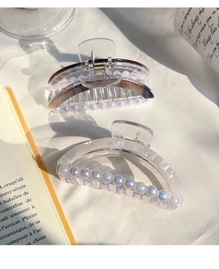 Détail de pinces à cheveux élégantes avec perles sur tissu blanc et lumière douce