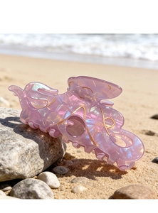 Pince à cheveux poulpe rose irisé avec détails de vagues dorées sur une plage ensoleillée