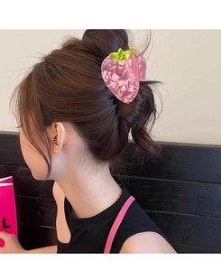 Pink strawberry hair claw clip with marble texture shown on hair in indoor setting